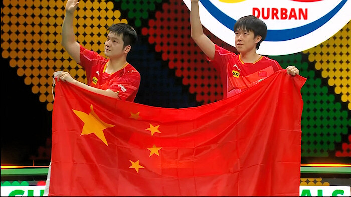 FAN Zhendong and WANG Chuqin celebrate with the China flag